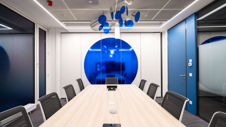 a symmetric composition of a ciroc's brand inspired conference room with printed blue circles and ciling decoration