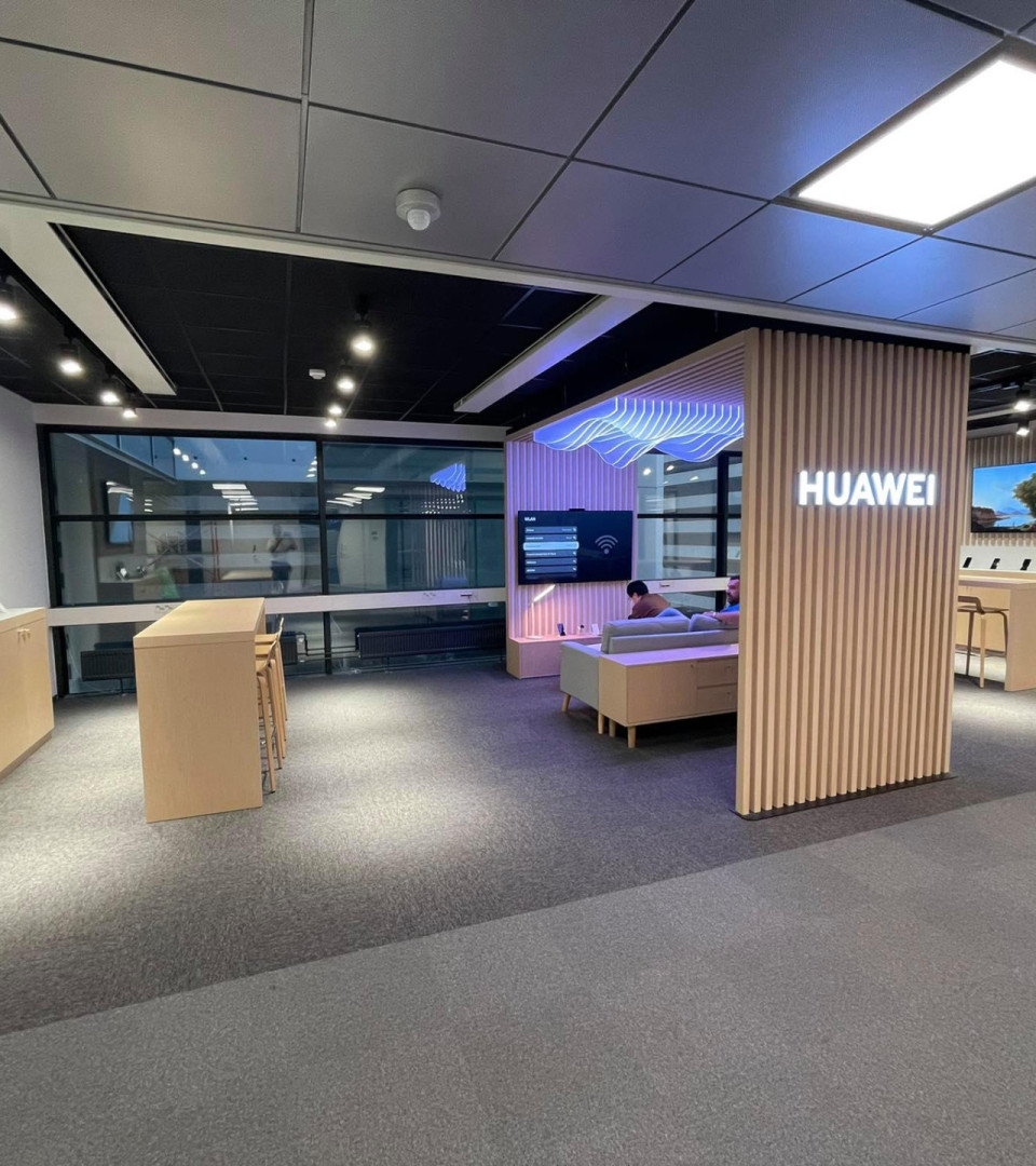 full view of Huawei's showroom with unique installations, frunitures and illuminated signage